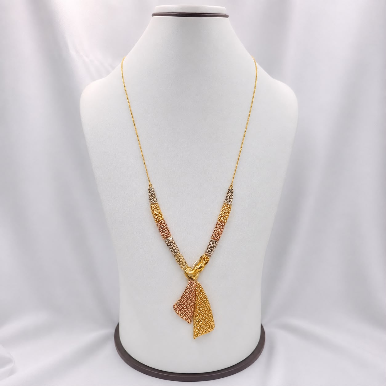 The Sable Knot necklace — two lattice panels gathered into a hand-finished knot